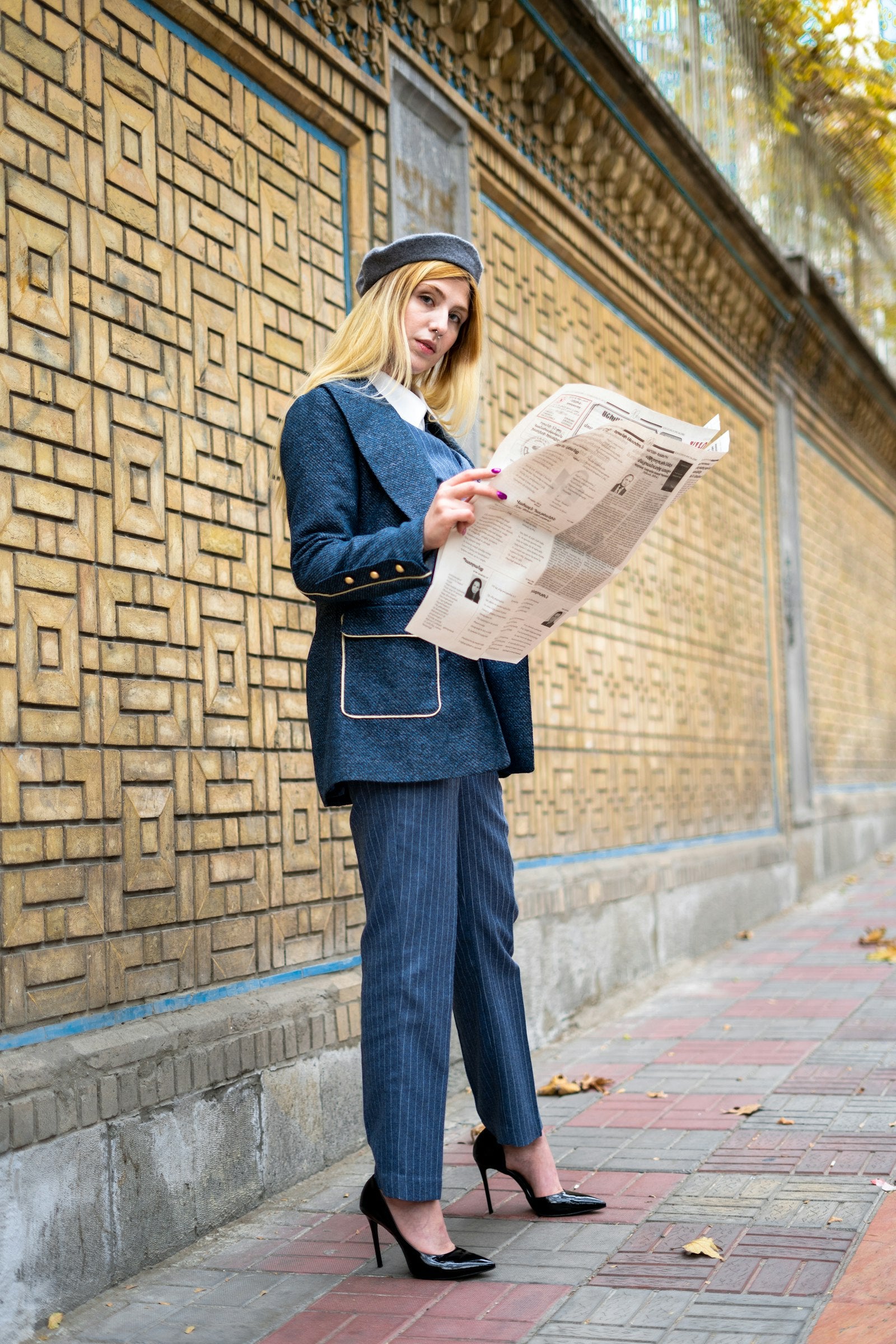 Donna con tailleur azzurro che legge il giornale in strada